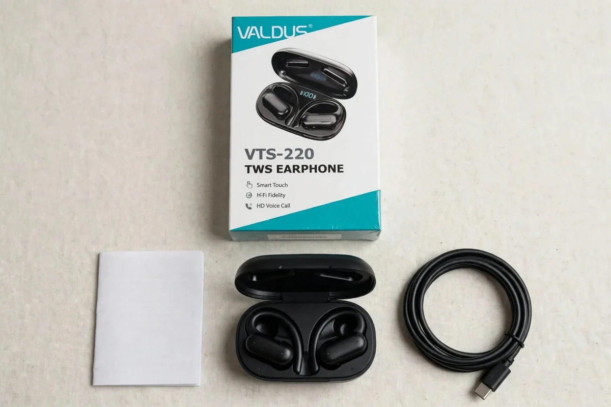 Flat lay of Valdus VTS-220 box contents: retail box, open case with buds, cable, manual