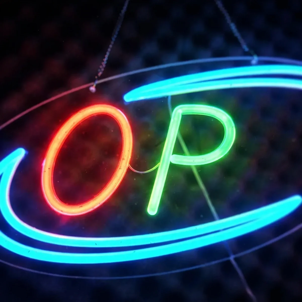Close-up of the glowing red O and green P letters on the GearUP OPEN20R neon sign