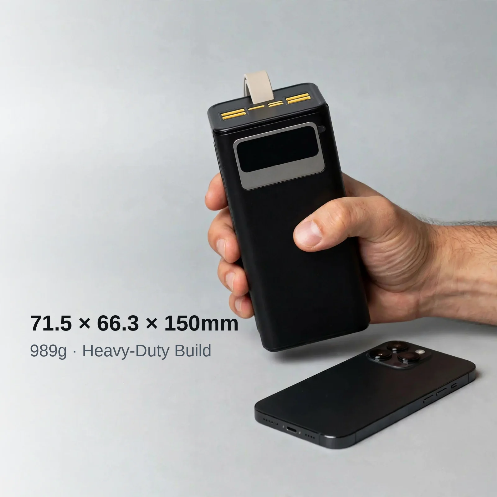 Hoco MMJ-12 held in hand next to a phone — 71.5 × 66.3 × 150mm, 989g heavy-duty build
