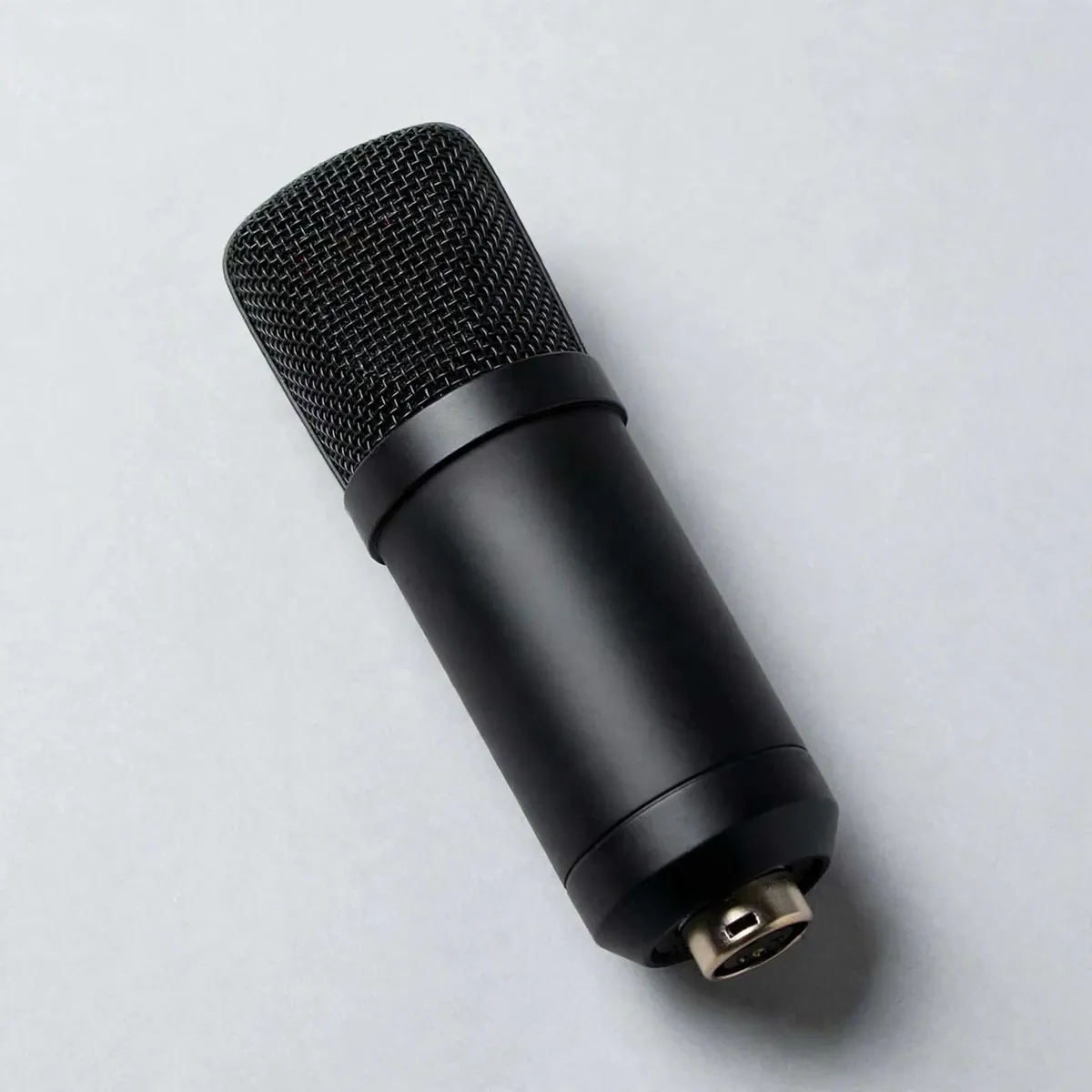 Maono AU-A03 studio photo showing the black condenser microphone with metal-mesh grille on a light grey background