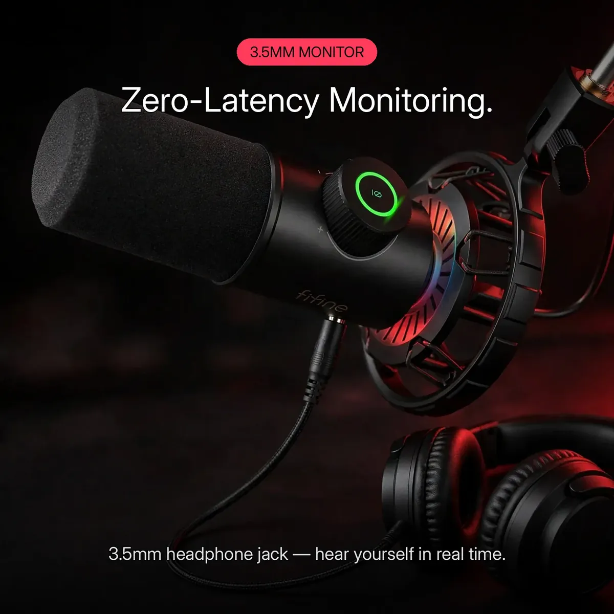 FIFINE K658 feature card showing headphones plugged into the microphone's 3.5mm monitoring jack — Zero-Latency Monitoring. 3.5mm headphone jack, hear yourself in real time.