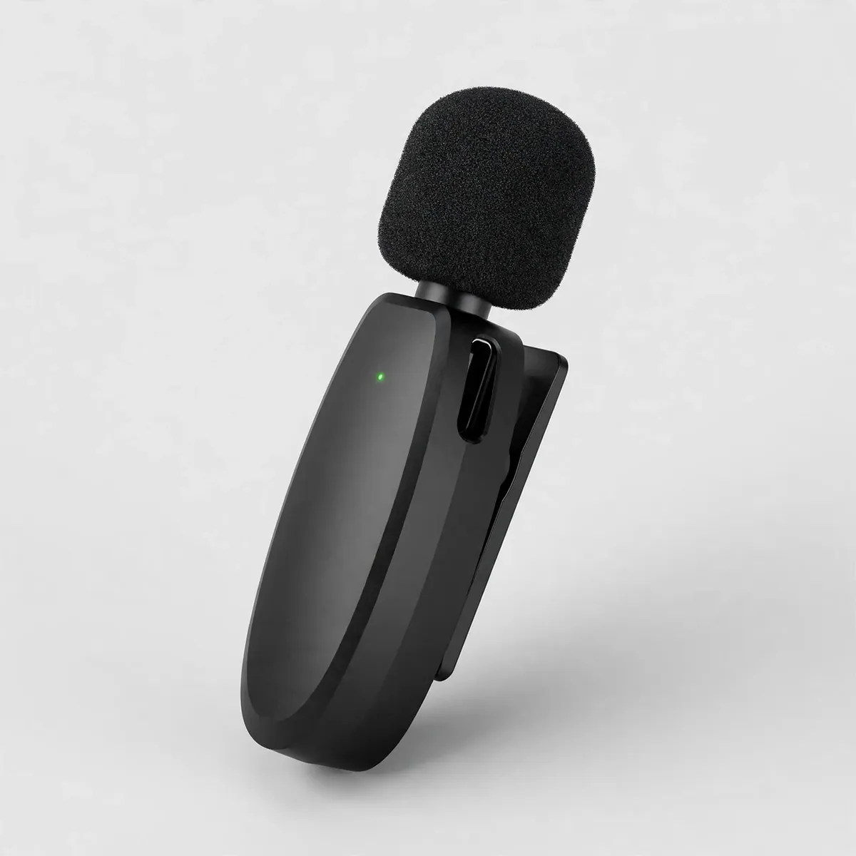 Hoco L15 front detail showing the oval black mic body, foam windscreen, back clip and green LED — the clip-on transmitter.