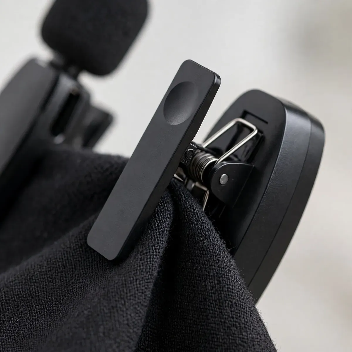 Hoco L15 clip detail showing the mic's back clip gripping dark shirt fabric — clips on and stays put.