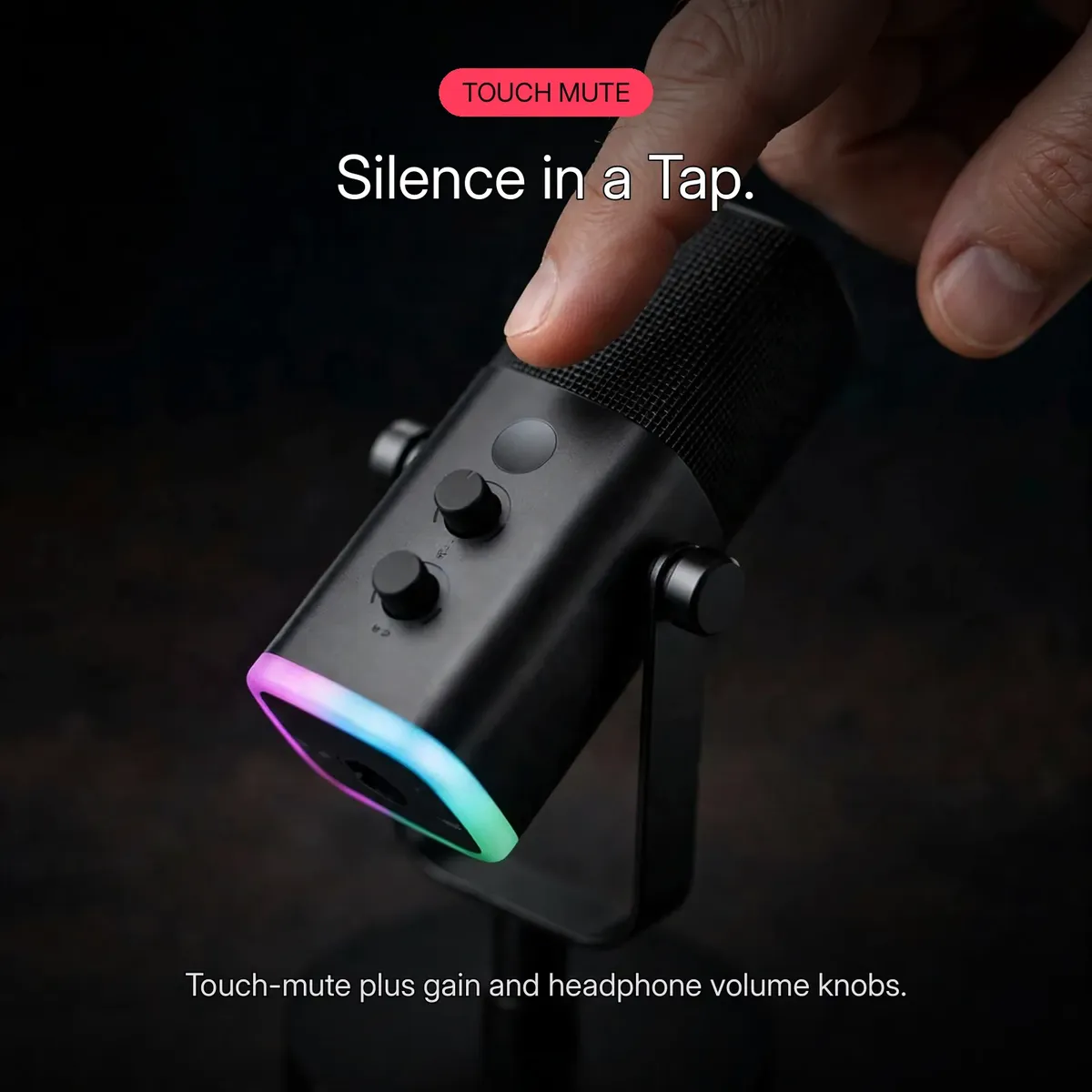 FIFINE AmpliGame AM8 close-up of a fingertip tapping the touch-mute button on top of the microphone — Silence in a Tap. Touch-mute plus gain and headphone volume knobs.