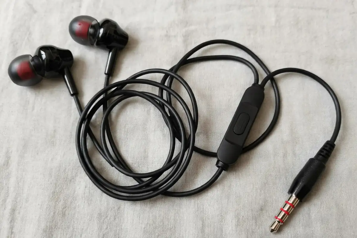 Flat lay of the Geeoo X10 earbuds with coiled 1.2m cable, inline control module and 3.5mm jack