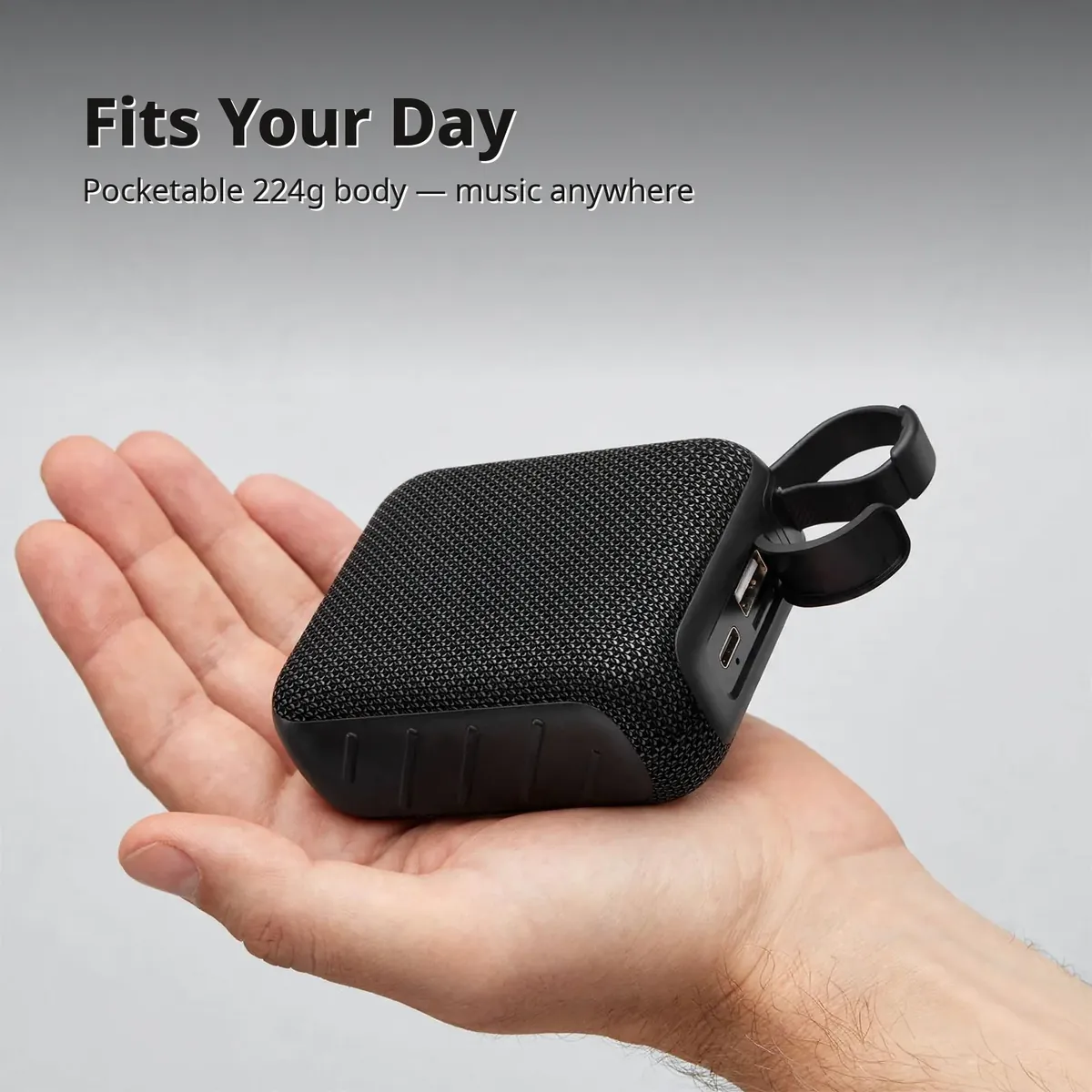 Hoco MMJ07 portable speaker resting in an open palm showing its pocketable 224g size