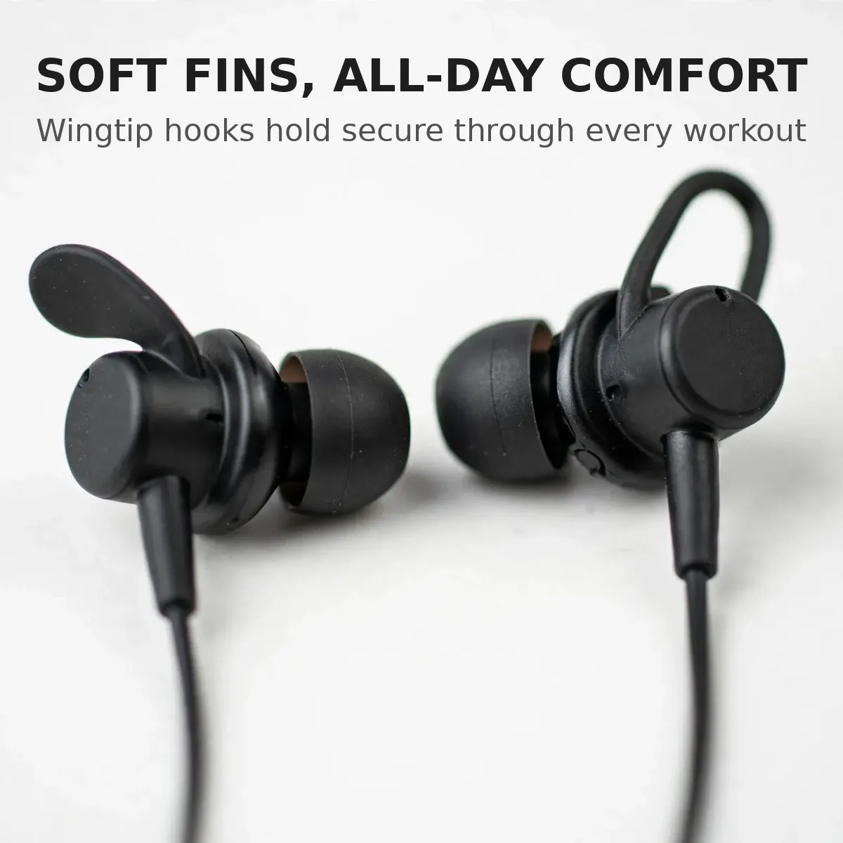 Philips TAN1120 wingtip earbud macro — Soft Fins, All-Day Comfort. Wingtip hooks hold secure through every workout.