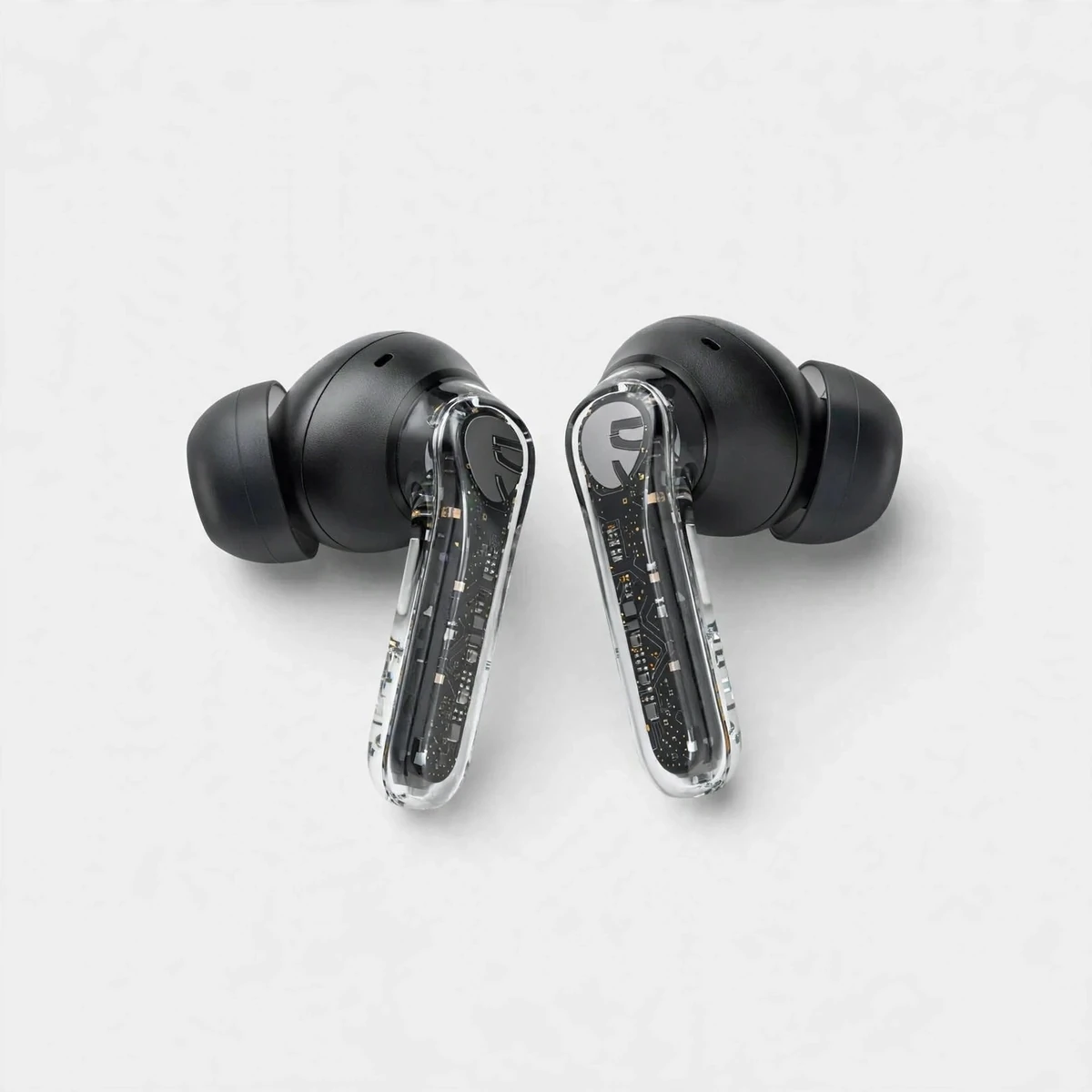 Pair of black SoundPEATS Clear earbuds with transparent stems on a neutral background