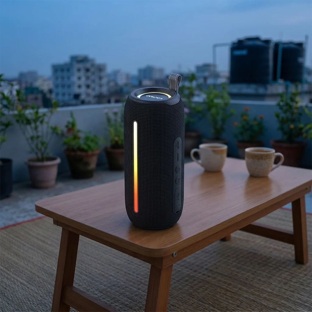 awei-y788-rgb-lights-rooftop-dusk Awei Y788 Bluetooth speaker with its RGB lights on, standing on a rooftop table at dusk